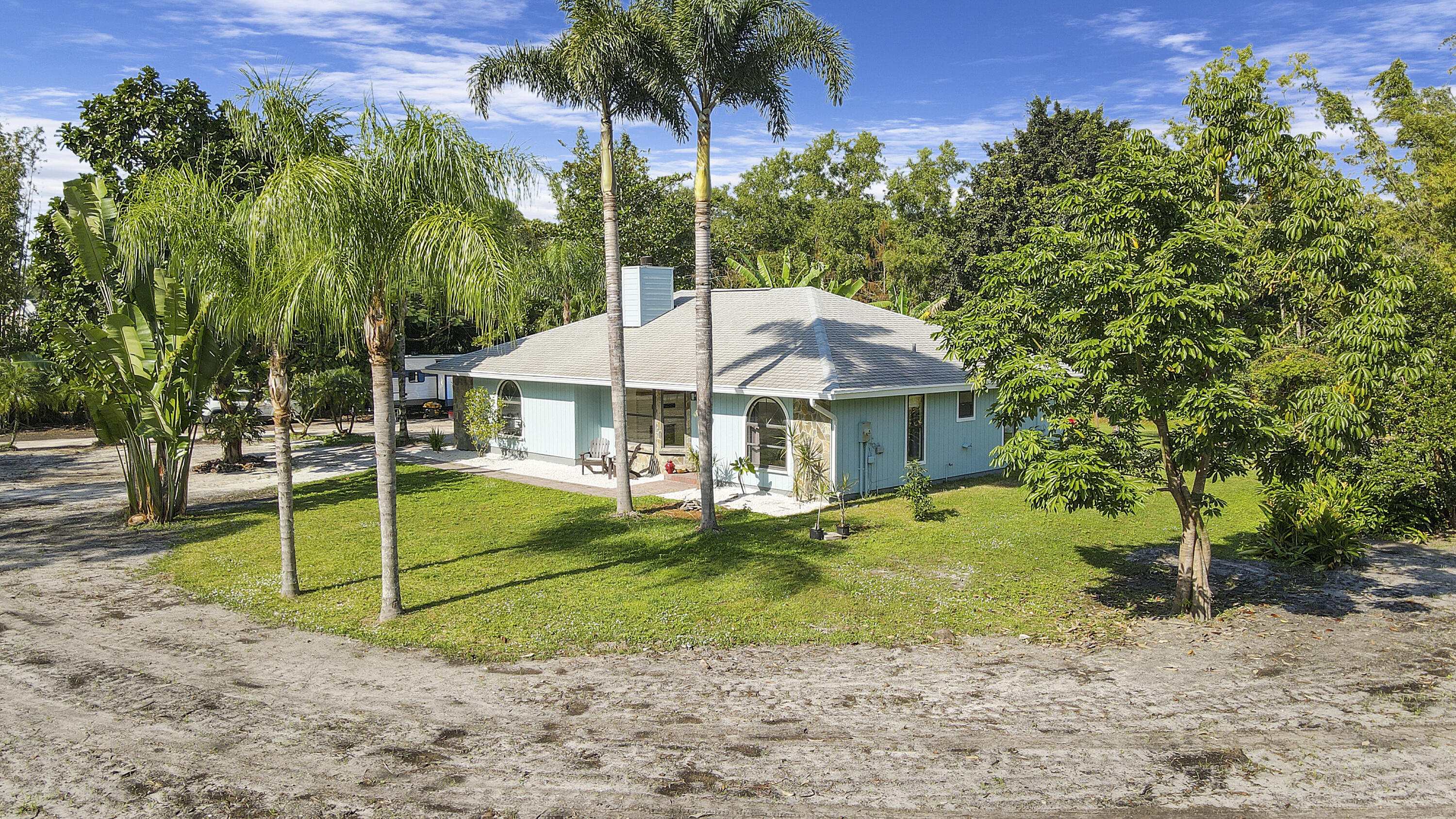 13431 153rd Road North Jupiter, FL 33478 - Photo 33 of 44 a white house with a small yard and palm trees