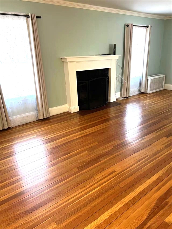 142 Jackson Street Newton, MA 02459 - Photo 12 of 16 an empty room with wooden floor fireplace and windows