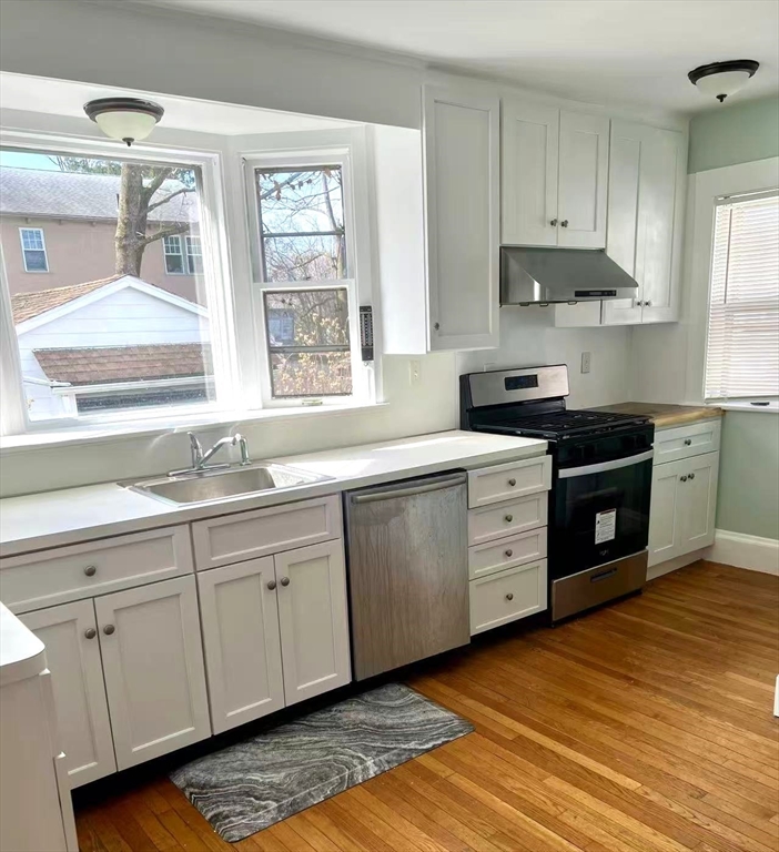 142 Jackson Street Newton, MA 02459 - Photo 8 of 16 a kitchen with granite countertop white cabinets sink and stainless steel appliances