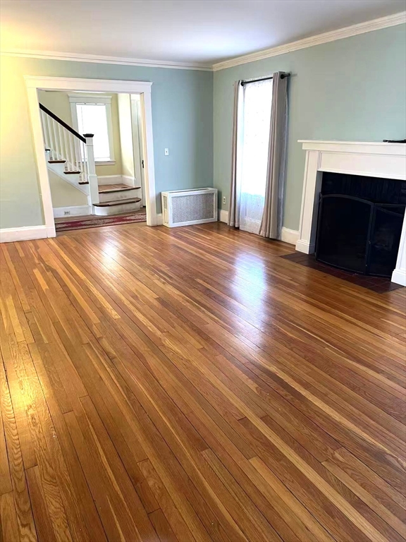 142 Jackson Street Newton, MA 02459 - Photo 10 of 16 an empty room with wooden floor and fireplace