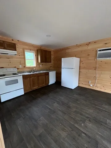 a kitchen with stainless steel appliances wooden floor and a sink