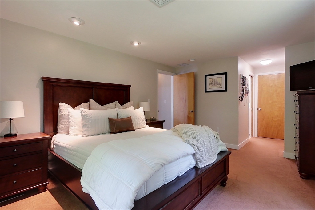 120 1/2 Lowell Road, Unit B Pepperell, MA 01463 - Photo 12 of 34 a bedroom with a bed and a flat screen tv