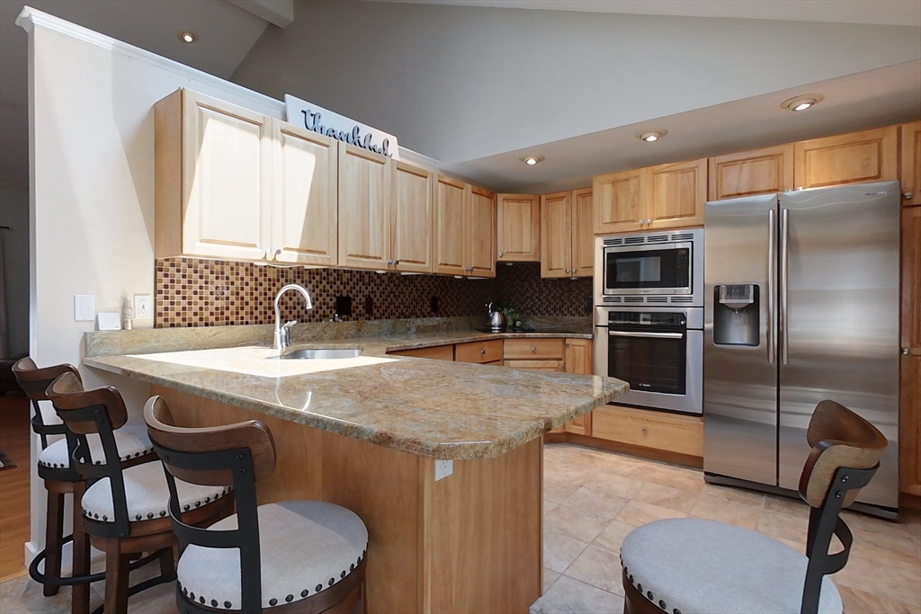 120 1/2 Lowell Road, Unit B Pepperell, MA 01463 - Photo 5 of 34 a kitchen with stainless steel appliances granite countertop a sink a microwave a refrigerator and chairs