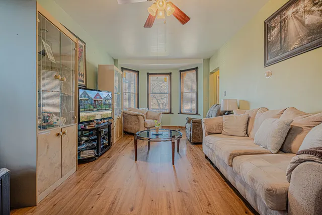 a living room with furniture a flat screen tv and a large window