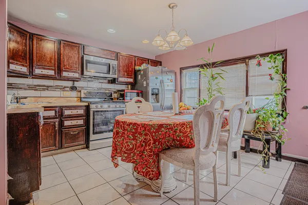 a kitchen with stainless steel appliances granite countertop a stove top oven a sink dishwasher a dining table and chairs with wooden floor