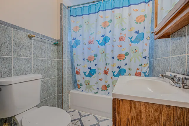 a bathroom with a sink a toilet and shower curtain