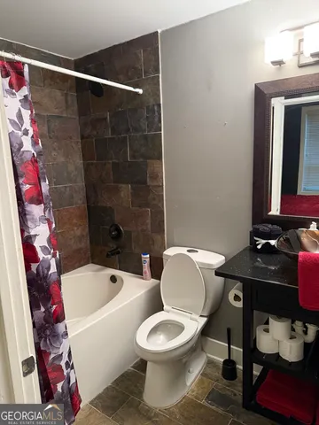 a white toilet sitting next to a bathroom sink and tub