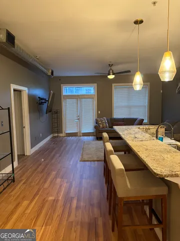 a large kitchen with kitchen island a stove a sink dishwasher and a wooden floor