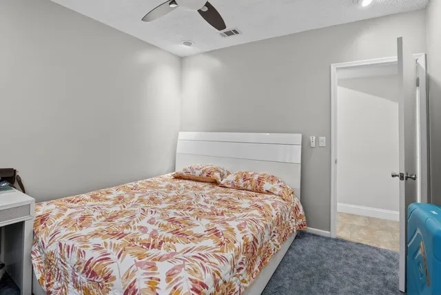 a spacious bedroom with a large bed and a chandelier