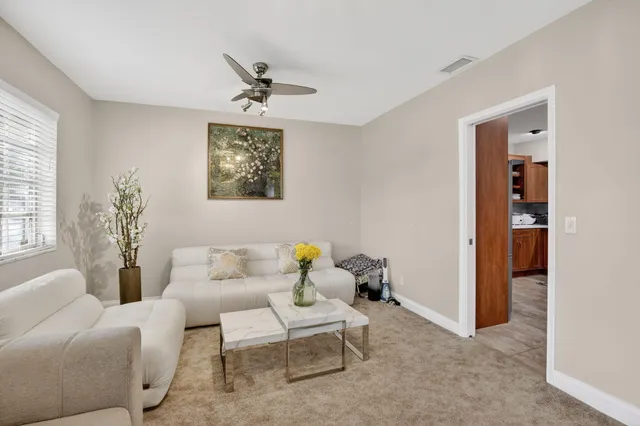 a living room with furniture flowerpot and a flat screen tv