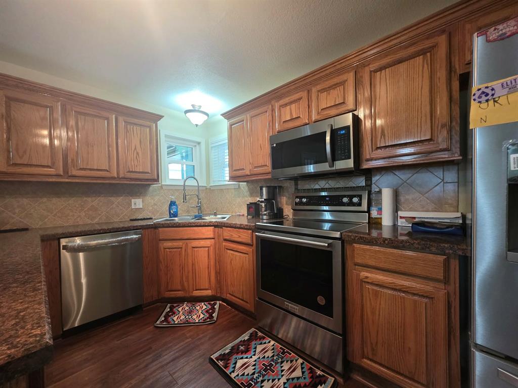 739 Bluebonnet Street Mexia, TX 76667 - Photo 10 of 28 a kitchen with stainless steel appliances granite countertop a stove sink microwave and cabinets