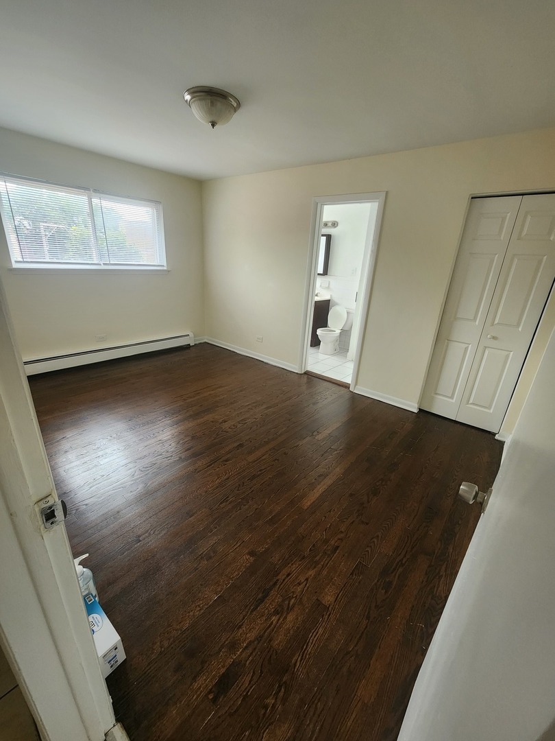 7455 North Ridge Boulevard, Unit C2 Chicago, IL 60645 - Photo 6 of 9 an empty room with wooden floor and windows