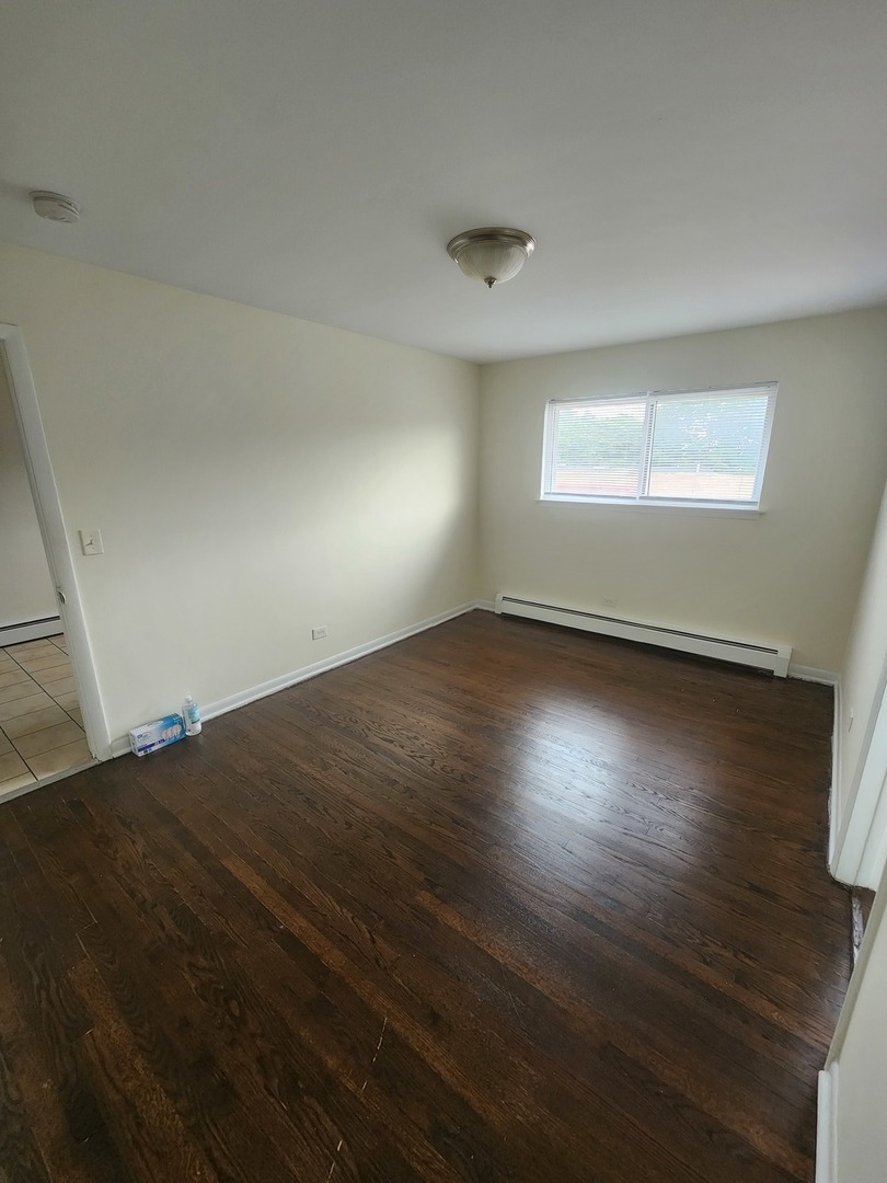 7455 North Ridge Boulevard, Unit C2 Chicago, IL 60645 - Photo 9 of 9 an empty room with wooden floor and windows