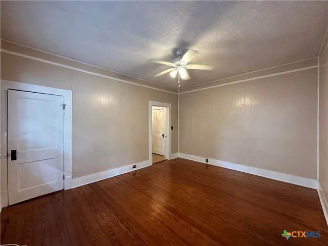 an empty room with wooden floor and window