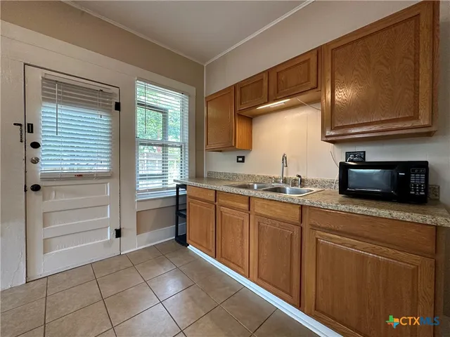 a kitchen with granite countertop a sink and cabinets