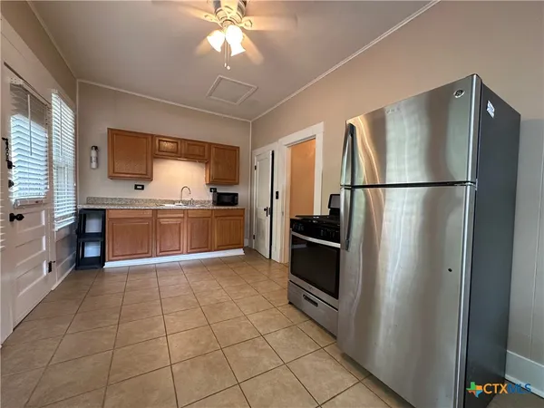 a kitchen with granite countertop a refrigerator and a sink
