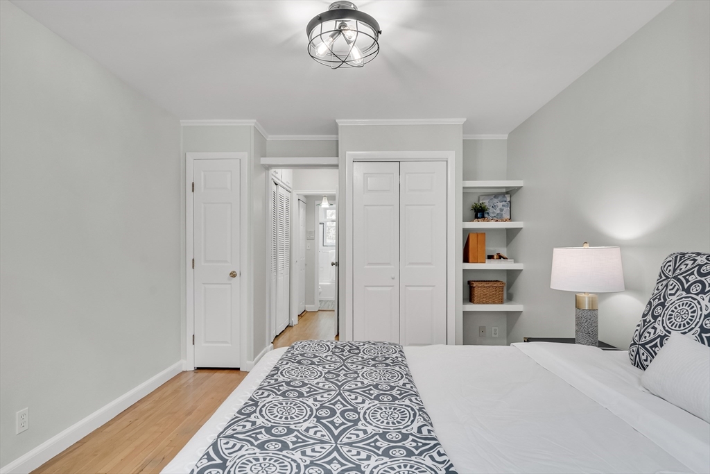 136 Beaconsfield Road, Unit 6 Brookline, MA 02445 - Photo 11 of 17 a bedroom with a bed and a chandelier