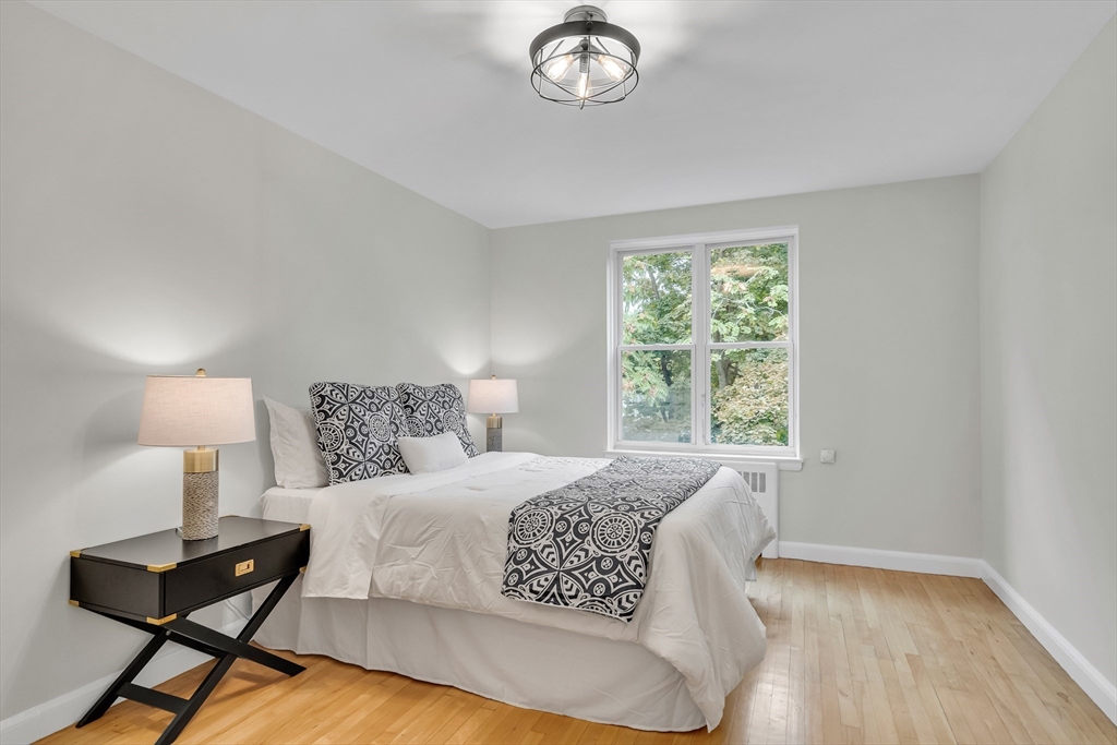 136 Beaconsfield Road, Unit 6 Brookline, MA 02445 - Photo 9 of 17 a bedroom with a bed and a lamp next to a window