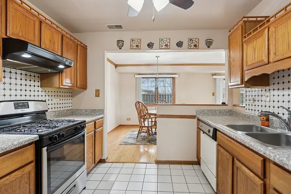 a kitchen with stainless steel appliances granite countertop a stove a sink and a microwave