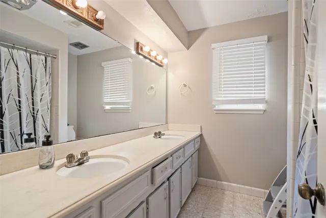 a bathroom with a double vanity sink and a mirror