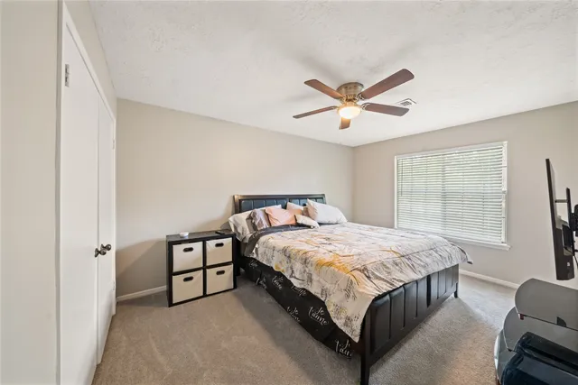 a bed sitting in a bedroom next to a window