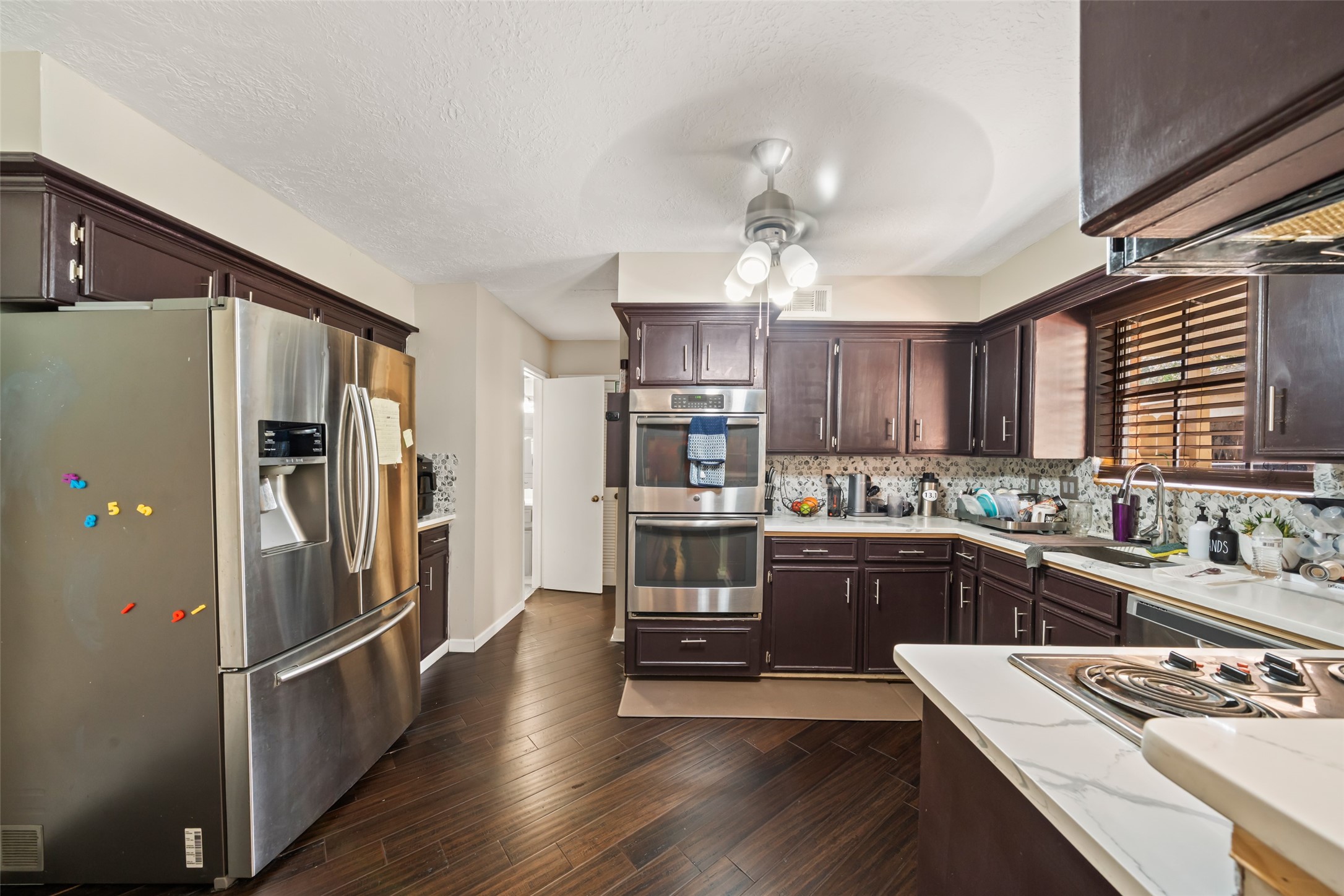 715 Marne Lane Houston, TX 77090 - Photo 3 of 25 a kitchen with a refrigerator and a stove top oven