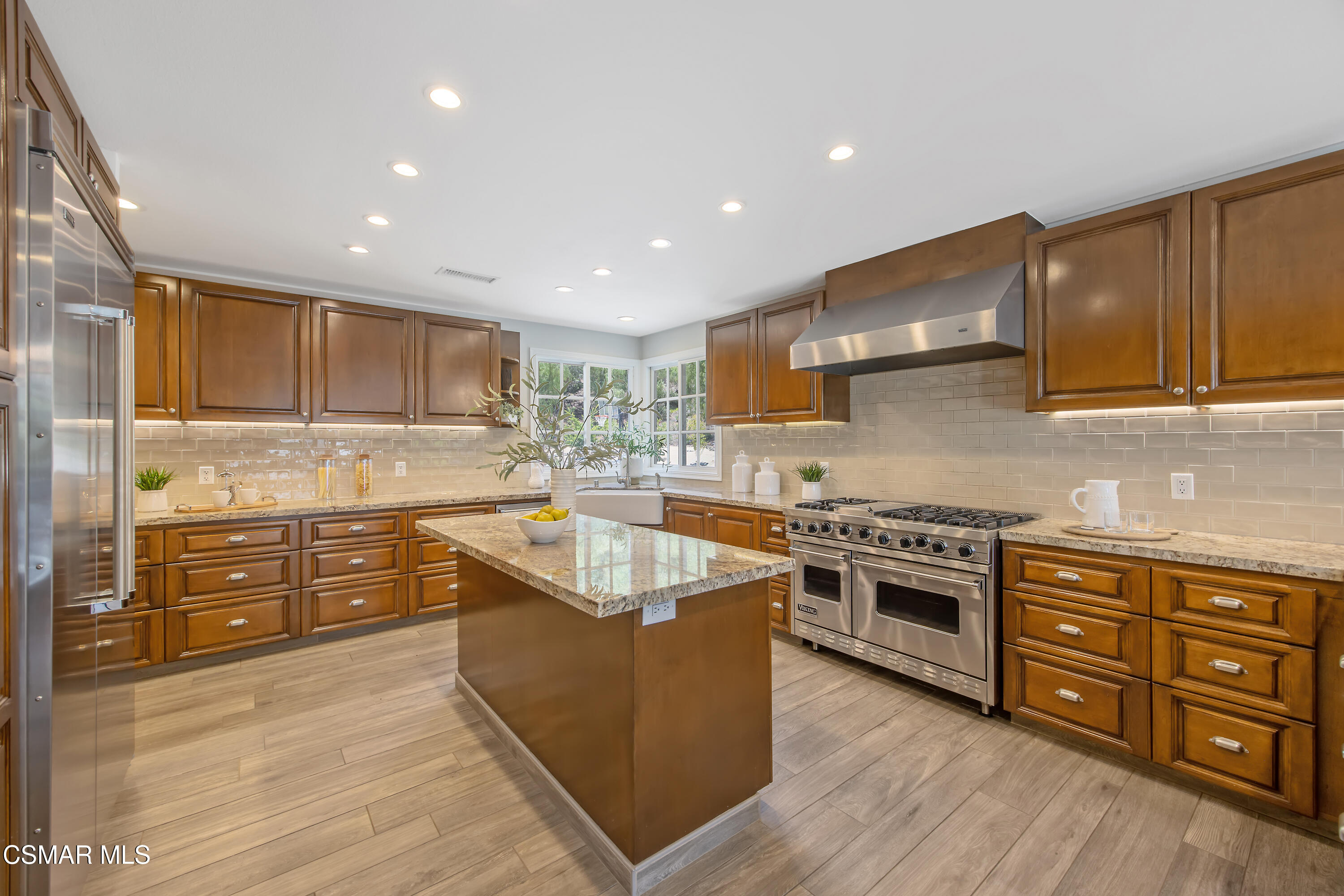 3840 Castle View Road Agoura Hills, CA 91301 - Photo 17 of 94 a kitchen with stainless steel appliances granite countertop a stove top oven a sink dishwasher and a oven with wooden cabinets