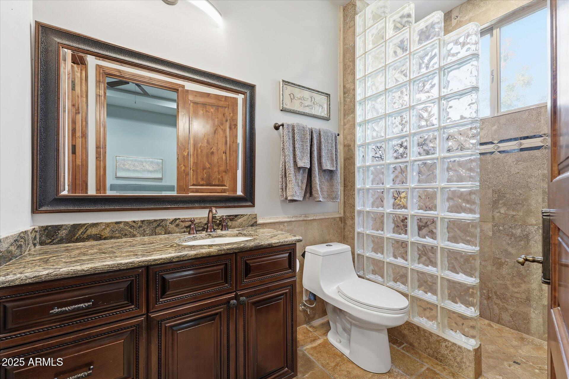 3121 East Bonanza Court Gilbert, AZ 85297 - Photo 57 of 83 a bathroom with a granite countertop toilet sink and mirror