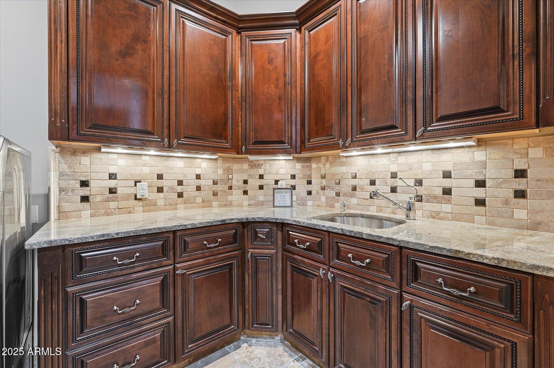 3121 East Bonanza Court Gilbert, AZ 85297 - Photo 59 of 83 a sink with granite countertop wooden cabinets