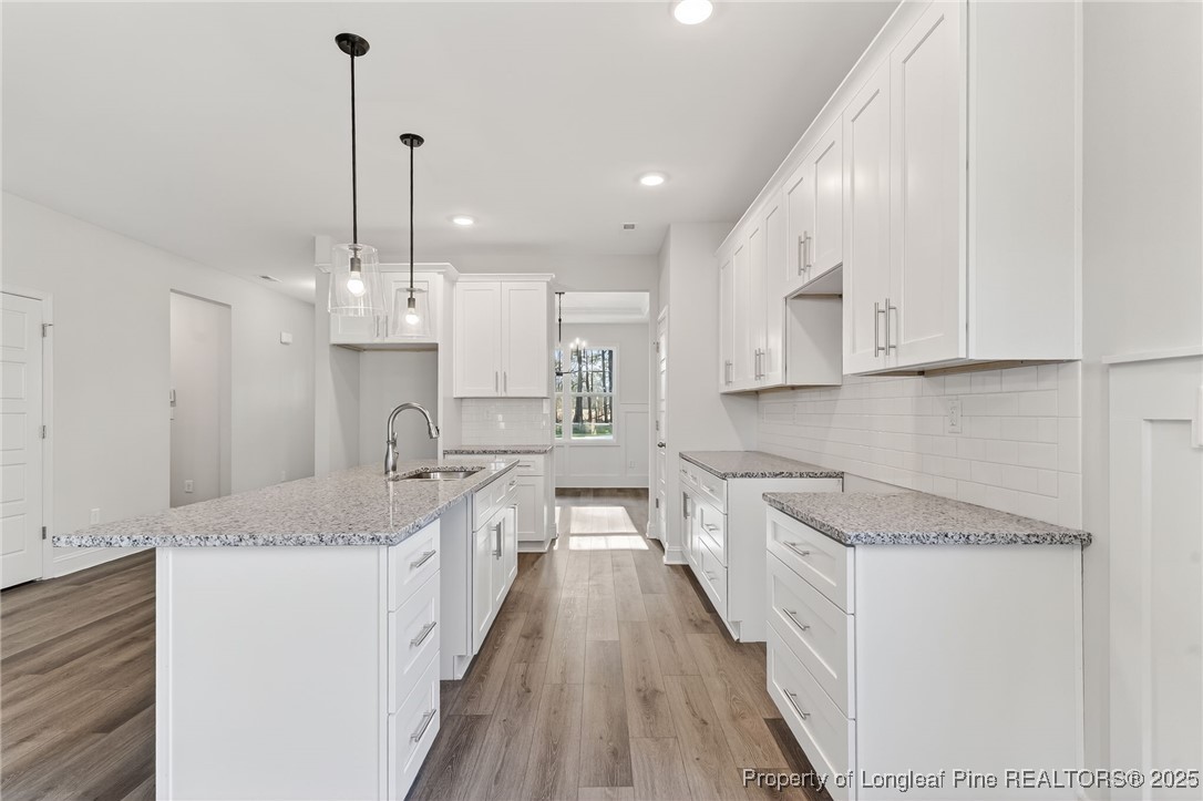 2154 Montrose (lot 6) Road Raeford, NC 28376 - Photo 16 of 44 a large kitchen with stainless steel appliances kitchen island granite countertop a sink a stove and a wooden floors