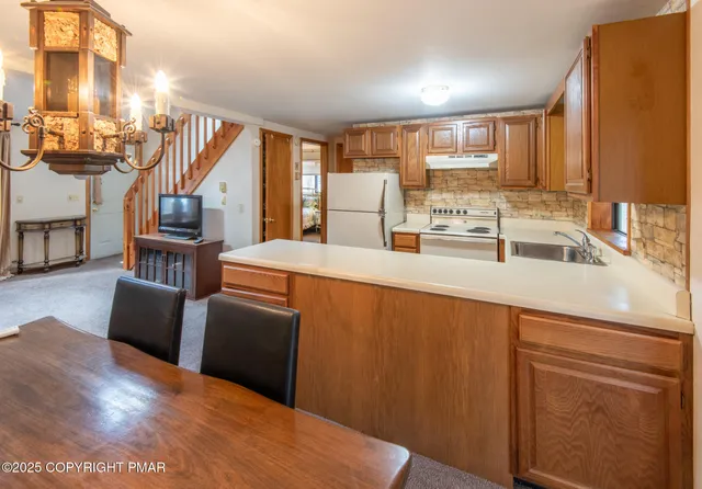 a kitchen with stainless steel appliances a sink dishwasher a refrigerator a stove with wooden floor and cabinets