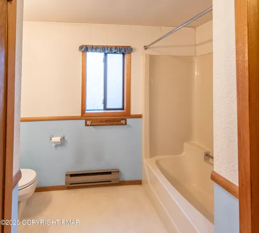 a bathroom with a granite countertop bathtub shower and a toilet
