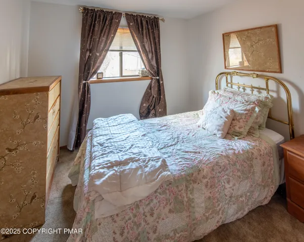 a bedroom with a bed next to a window