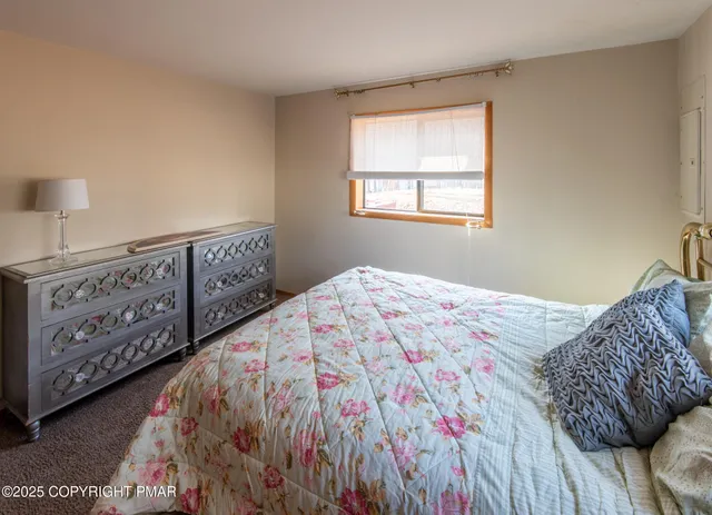 a bedroom with a bed a dresser and a window