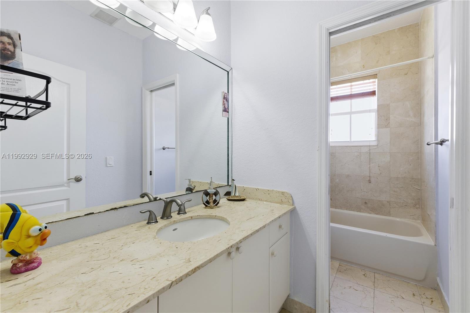 15184 Southwest 20th Street Miami, FL 33185 - Photo 13 of 39 a bathroom with a granite countertop sink a mirror and a bathtub