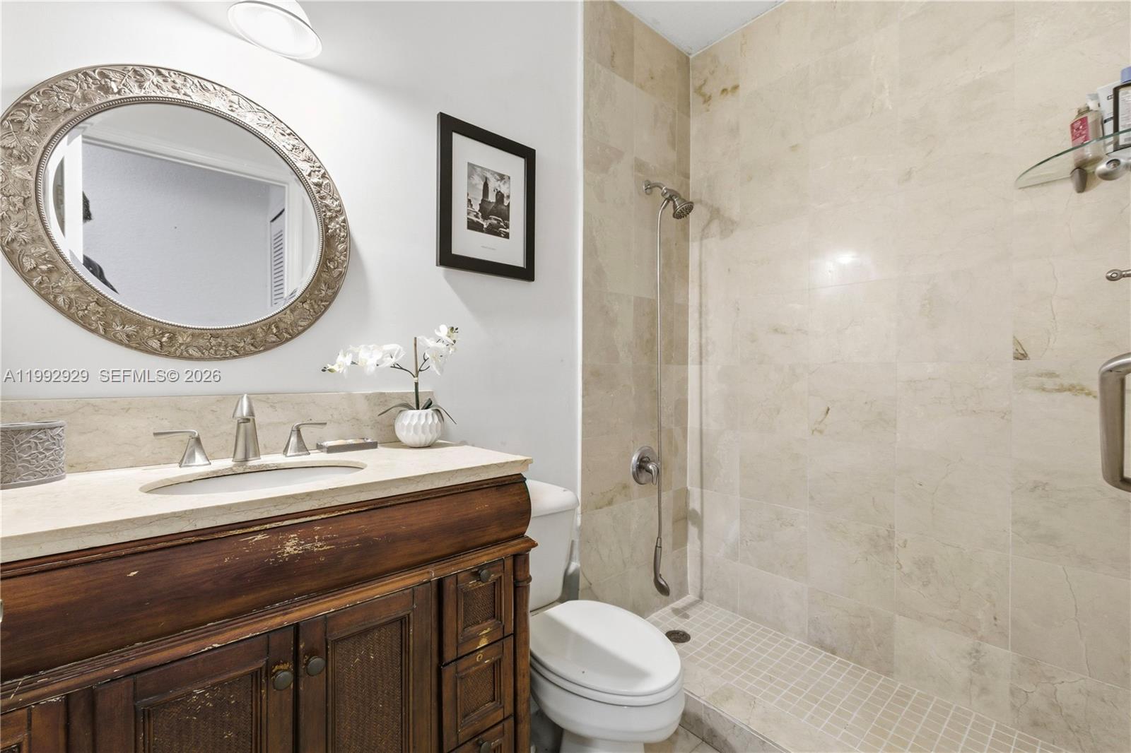 15184 Southwest 20th Street Miami, FL 33185 - Photo 26 of 39 a bathroom with a granite countertop toilet a sink and a mirror