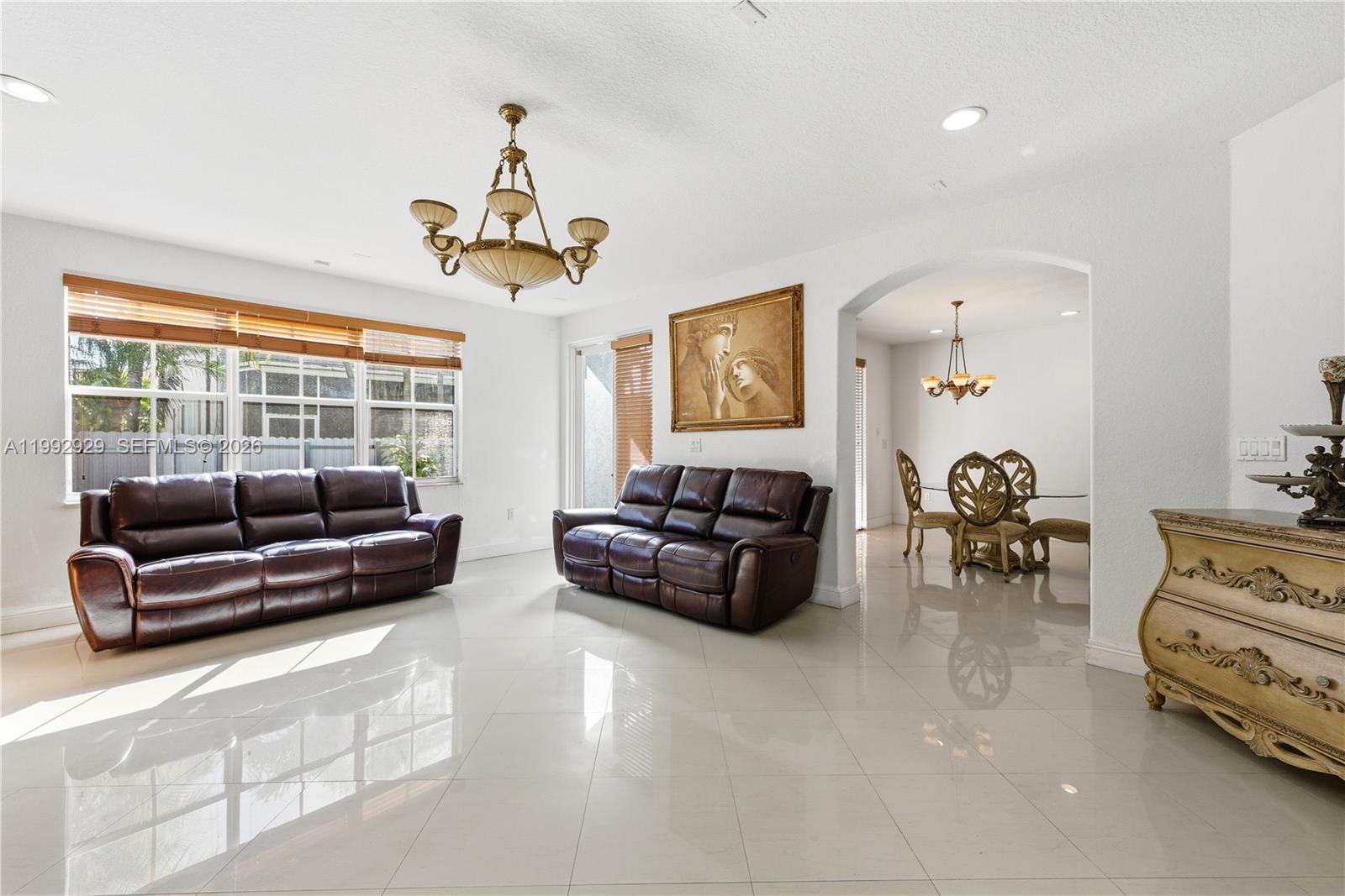 15184 Southwest 20th Street Miami, FL 33185 - Photo 35 of 39 a living room with furniture a chandelier and a window