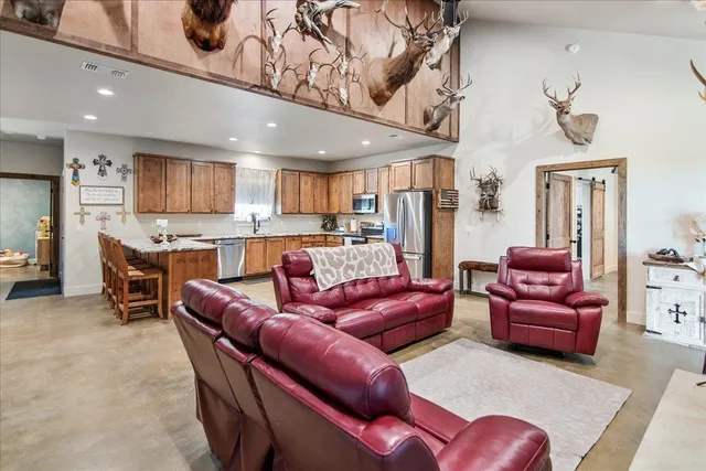 a living room with stainless steel appliances furniture and a kitchen