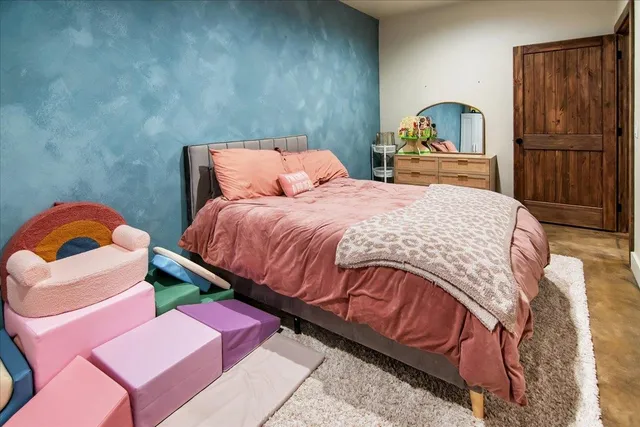 a bedroom with bed and wooden floor