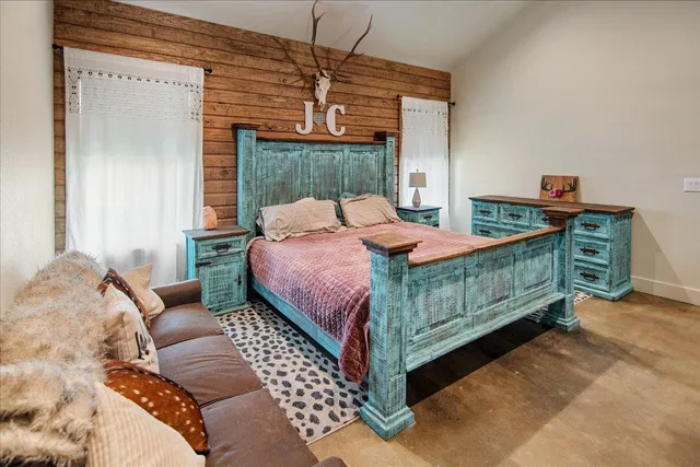 a bedroom with a bed a chandelier and a dresser