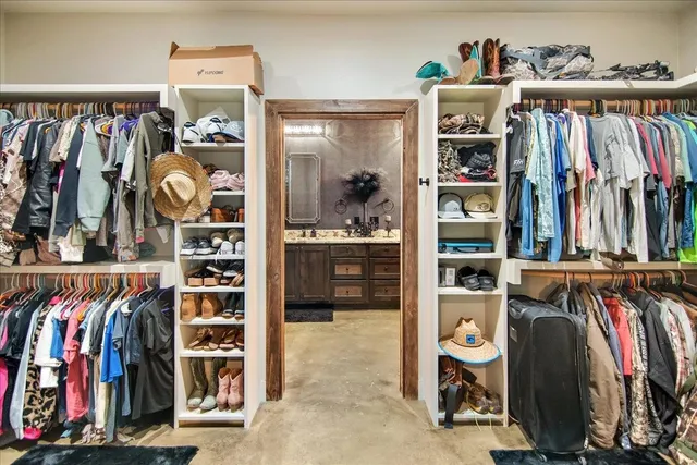 a view of walk in closet with clothes and shoes