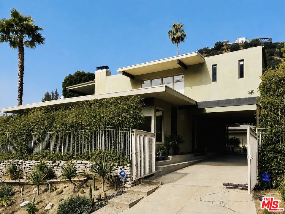 1555 Rising Glen Road Los Angeles, CA 90069 - Photo 1 of 19 a front view of a house with a yard and garage