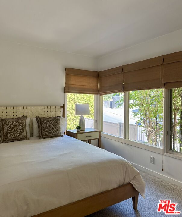 1555 Rising Glen Road Los Angeles, CA 90069 - Photo 16 of 19 a spacious bedroom with a large bed and a large window