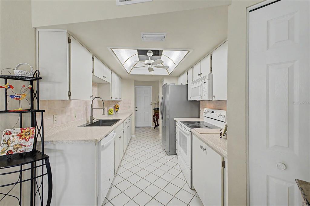 2662 Appleleaf Court Spring Hill, FL 34606 - Photo 11 of 47 a kitchen with stainless steel appliances kitchen island granite countertop a sink and cabinets