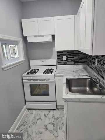a white stove top oven sitting inside of a kitchen
