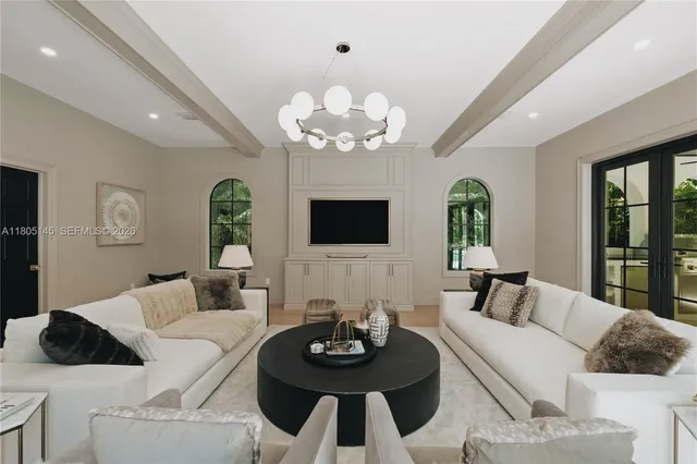 a living room with furniture a chandelier and a flat screen tv
