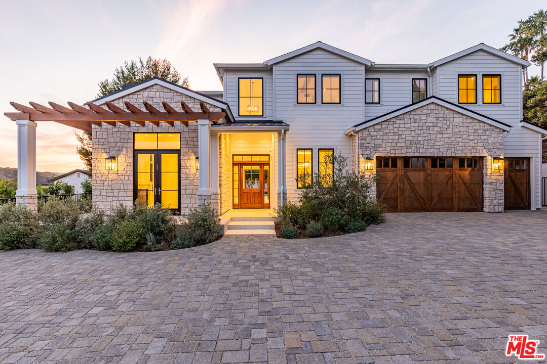 a view of a brick house with large windows and a yard