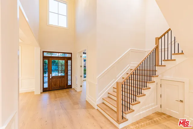 a view of staircase with railing and white walls