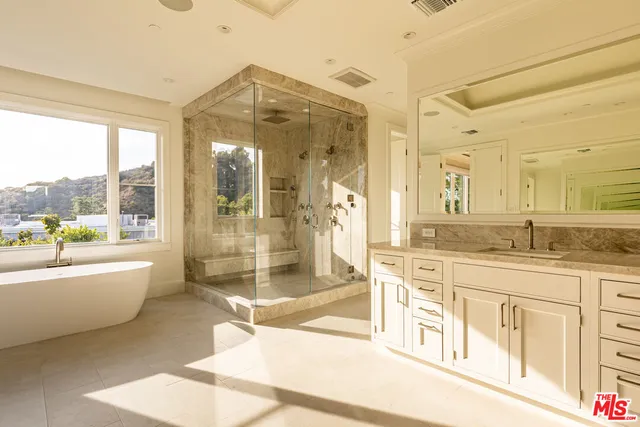a spacious bathroom with a granite countertop sink mirror and a bath tub