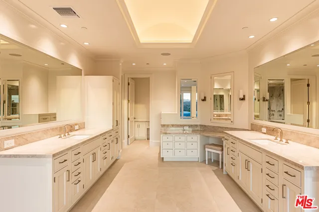 a large bathroom with double vanity and mirrors